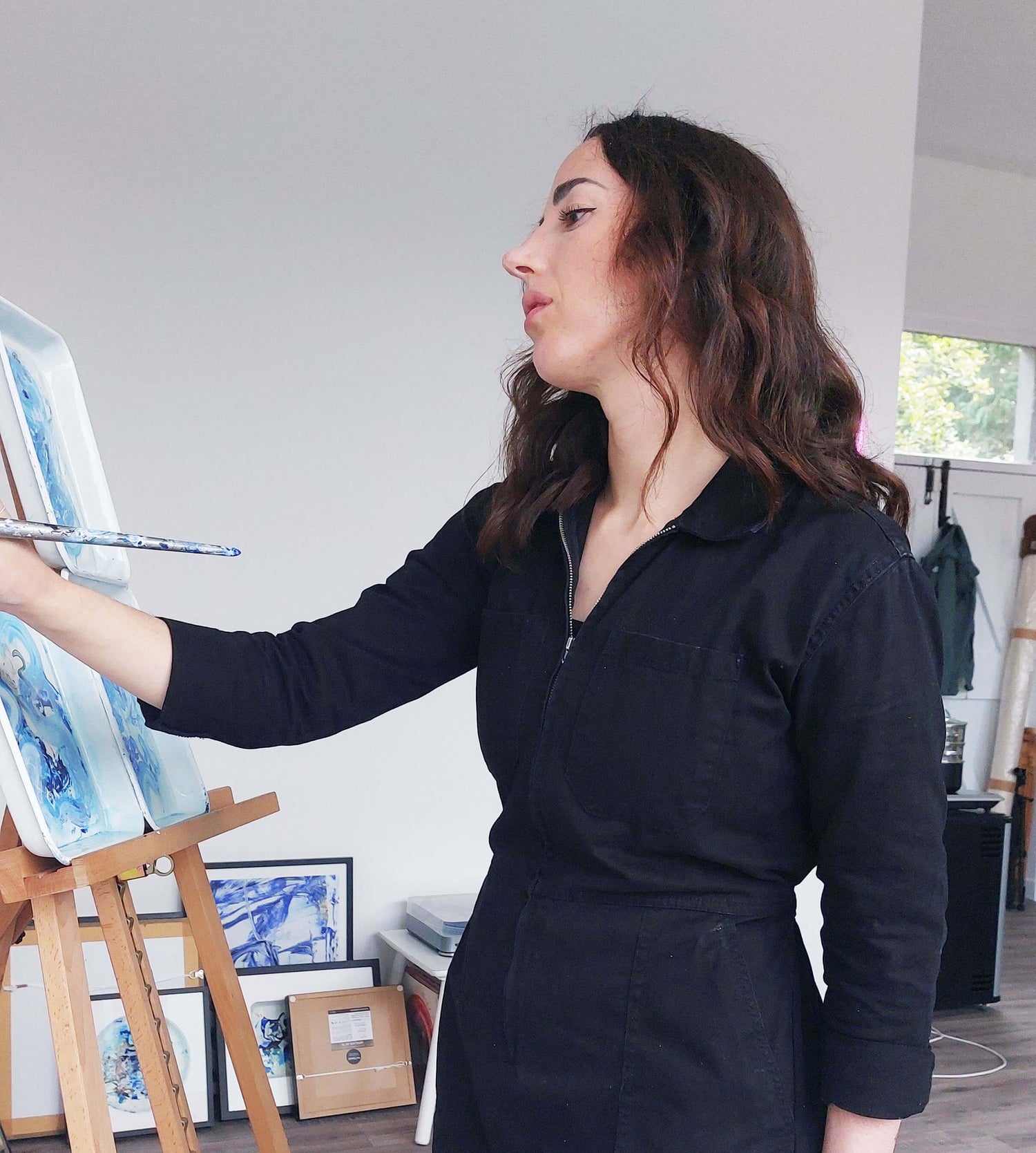 Irish artist Bridie Keogh painting on an easel in her art studio